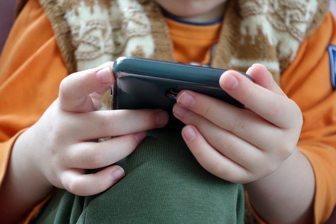close up of a child playing with a smartphone, very close up of hand and mobile phone,